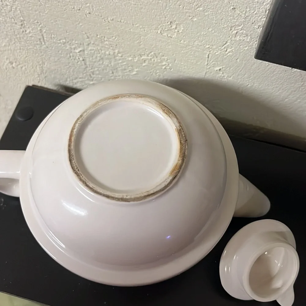 Small white teapot with violet and bee details.